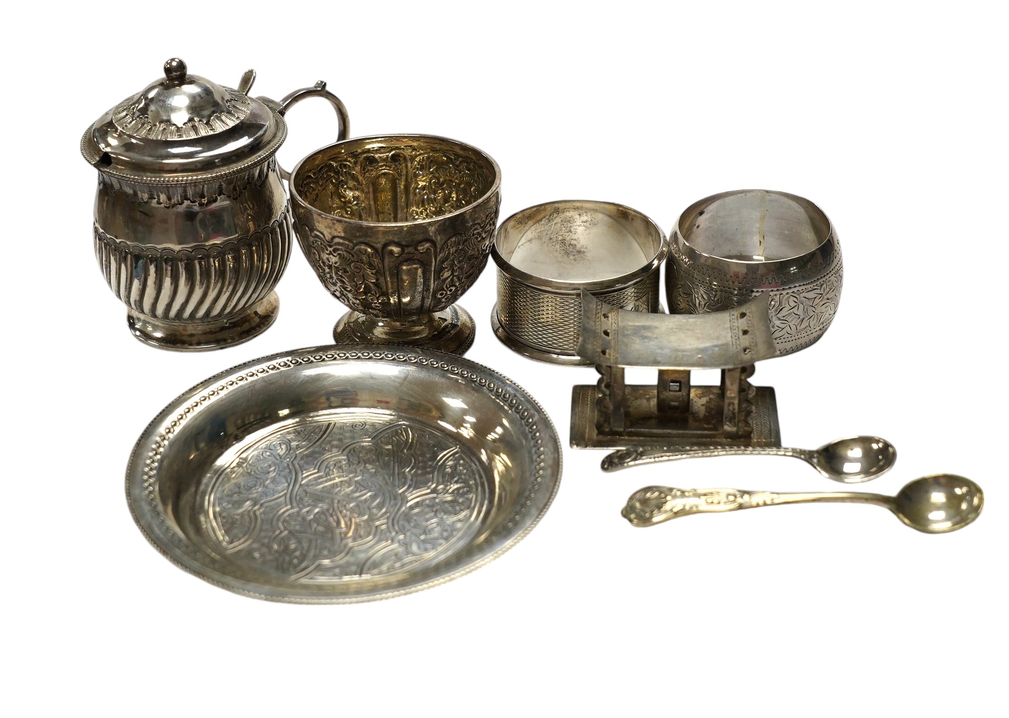 Sundry small silver including five silver napkin rings, and 800 napkin ring, a Victorian silver mustard and salt, an Egyptian small white metal dish, three silver condiment spoons and five plated items. Condition - poor